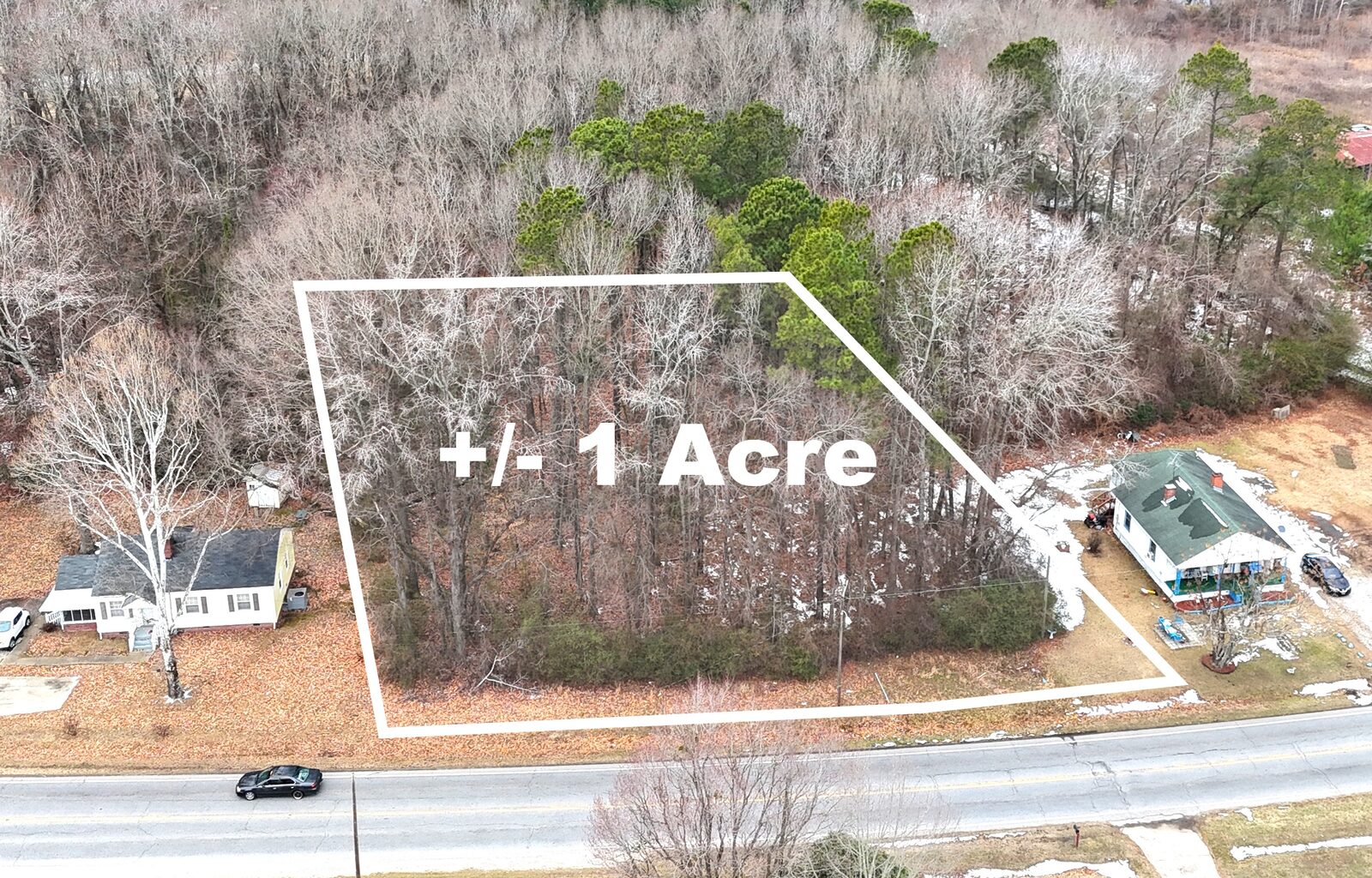 Aerial view of the wooded one-acre lot on Hathaway Street with its boundary outlined in white, a house on each side and the road along the front.