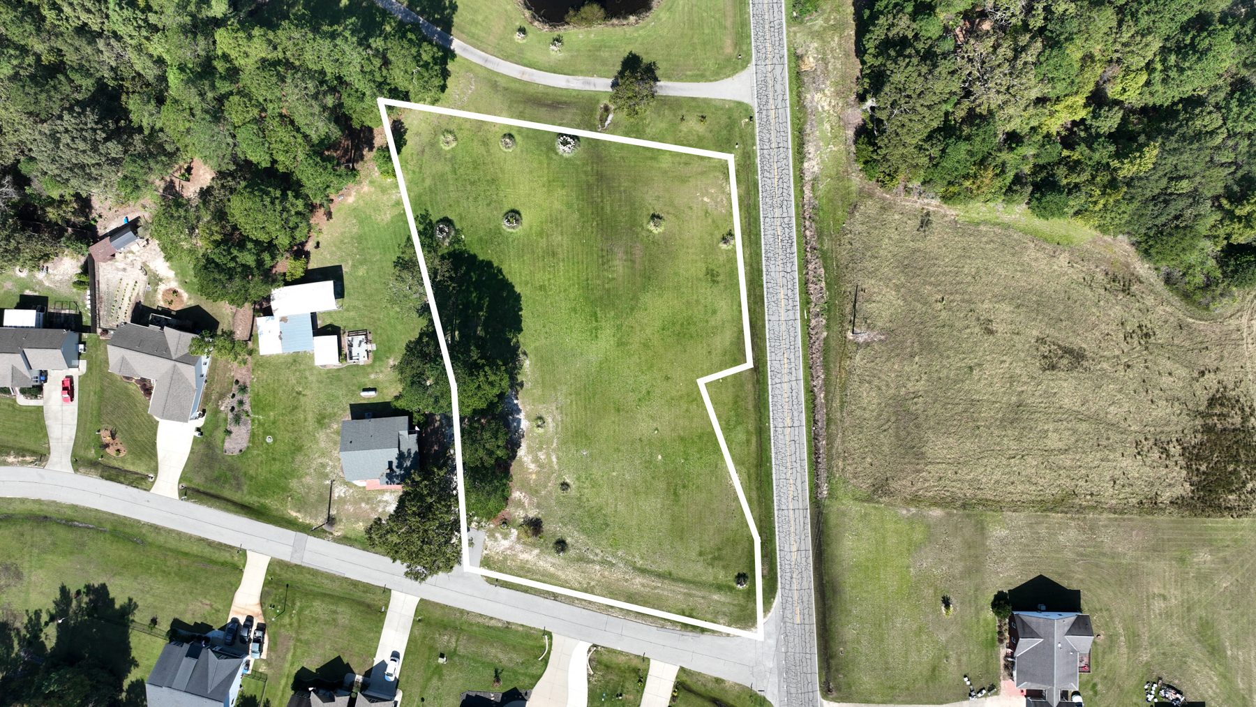 Drone view straight down on the corner lots with a white outline drawn around them, Old Stage Road on the right.